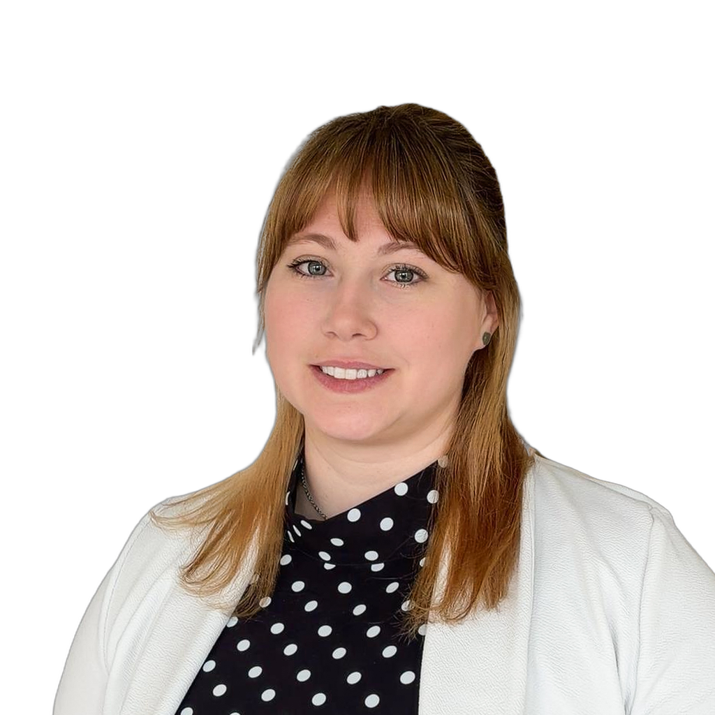 12. Female nurse practitioner. Young woman with red hair wearing a polka dot blouse and white cardigan against a textured grey background