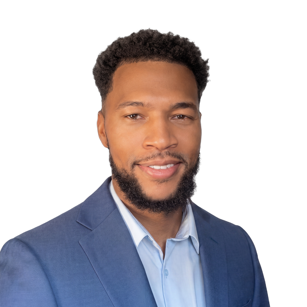 18. Hospital CEO. Black man in a blue blazer against a solid black background