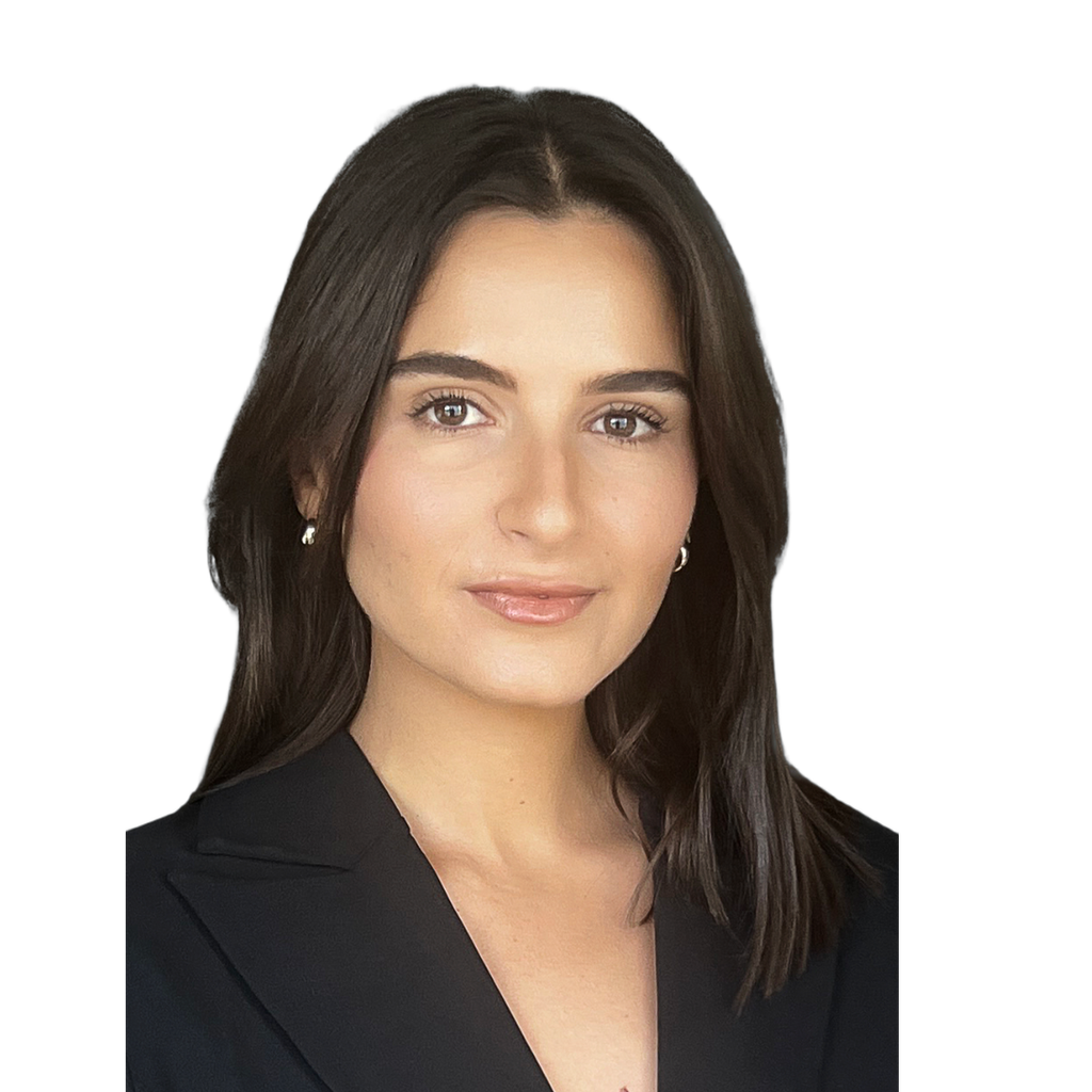 20. Female finance partner. Young adult woman in a black blazer against a light blue-grey background