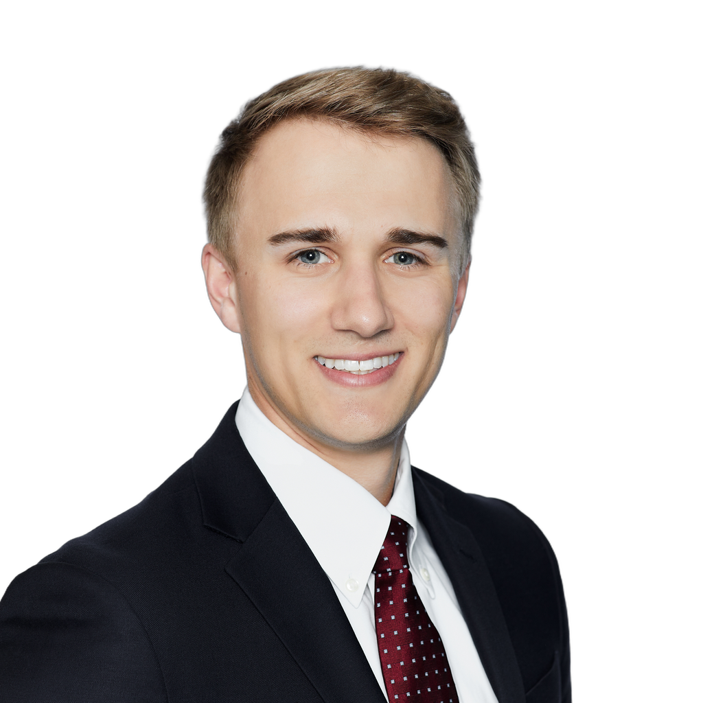 24. Insurance executive. Smiling young man in a dark suit and red tie, set against a clean white background