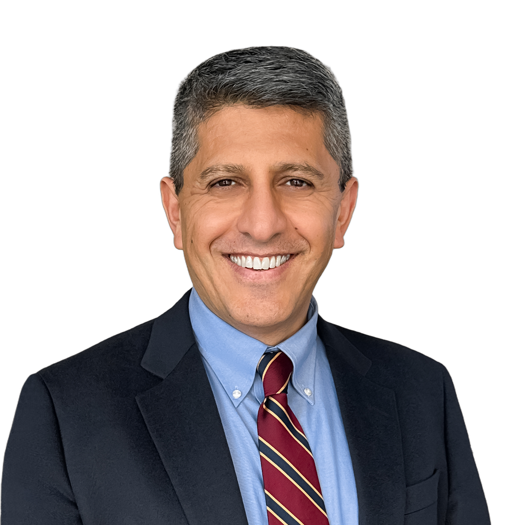 25. PE associate. Smiling middle-aged man in business formal attire against a plain beige background