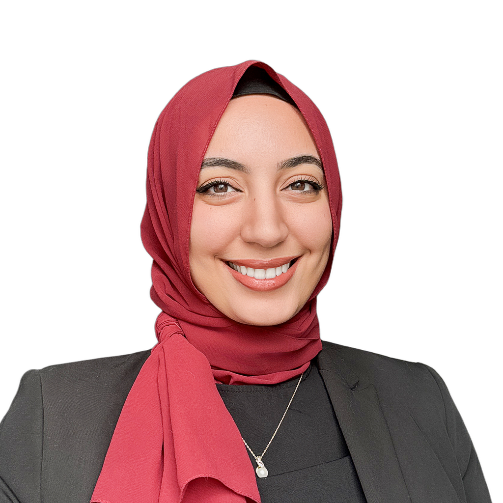 35. Compass team lead. Smiling woman wearing a red hijab and a dark blazer against a plain white background