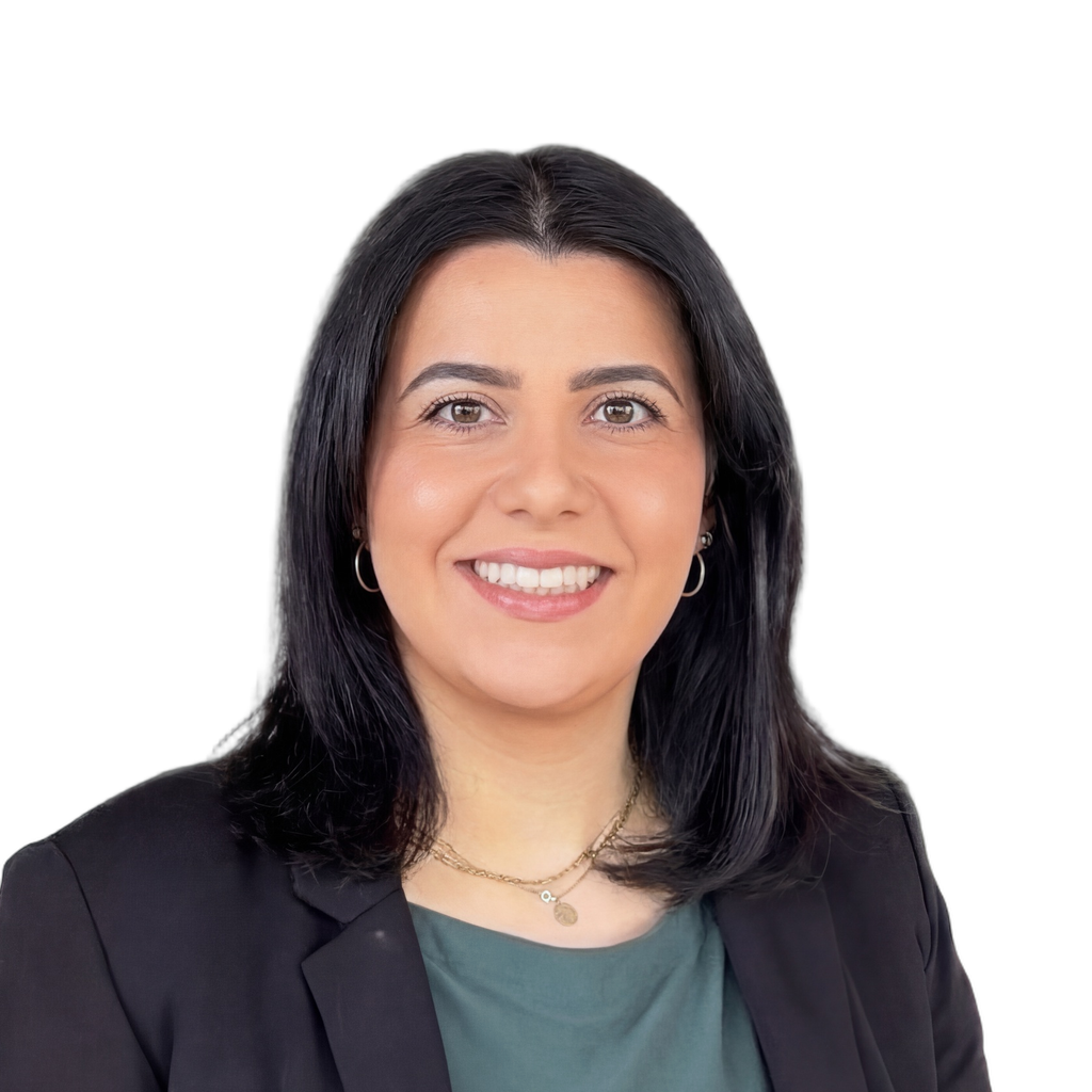 36. KW agent. Woman wearing a black blazer and green top against a blurred office background