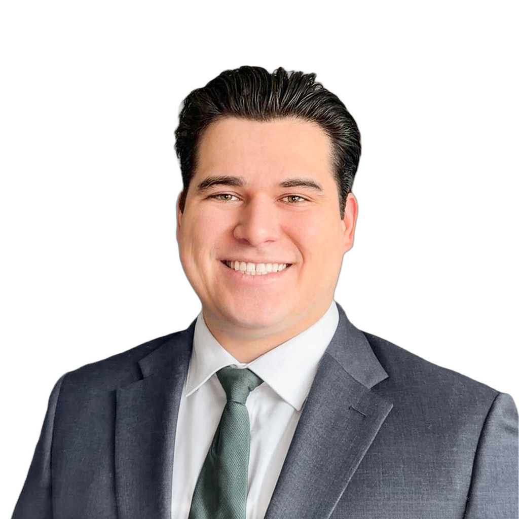 37. Northeast broker. Man in a grey suit and green tie against a blurred office interior background