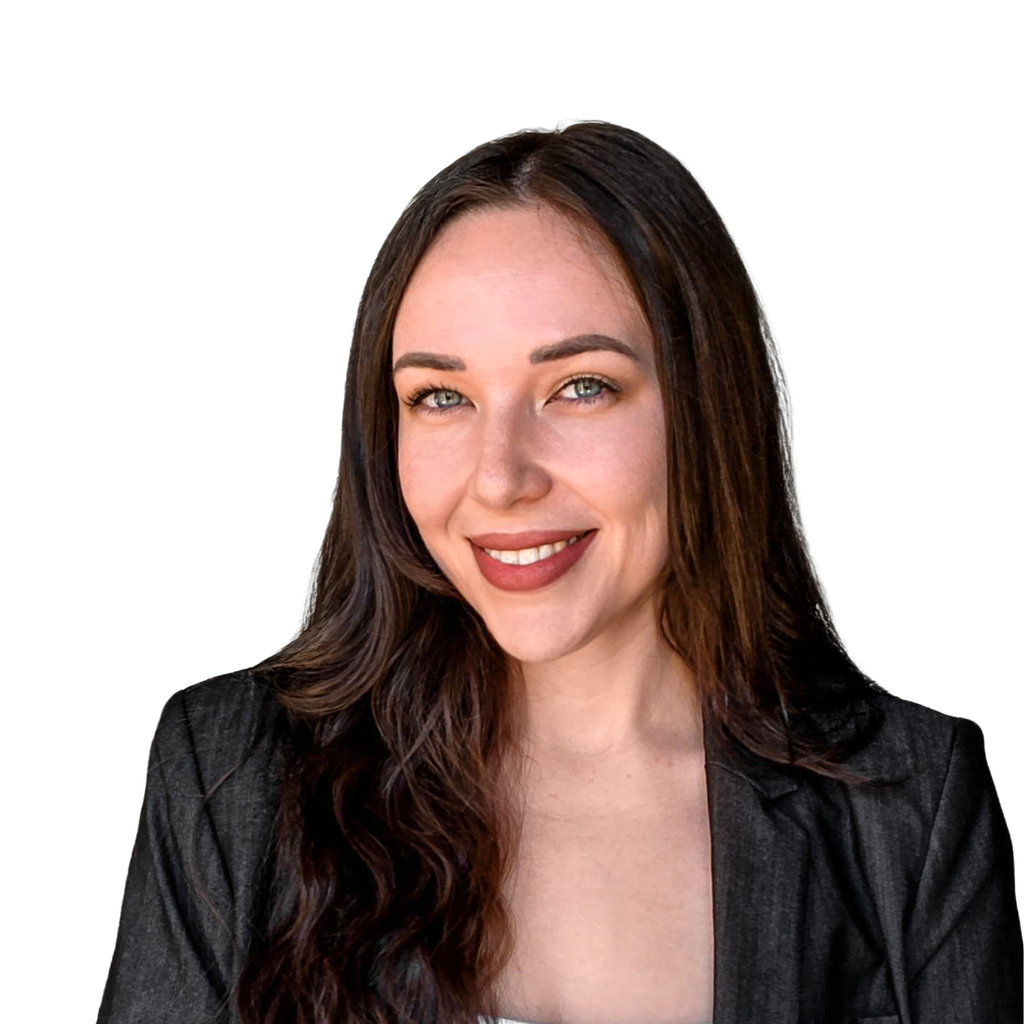 38. Female team principal. Young woman with long dark hair wearing a dark blazer over a white top, set against a solid black background