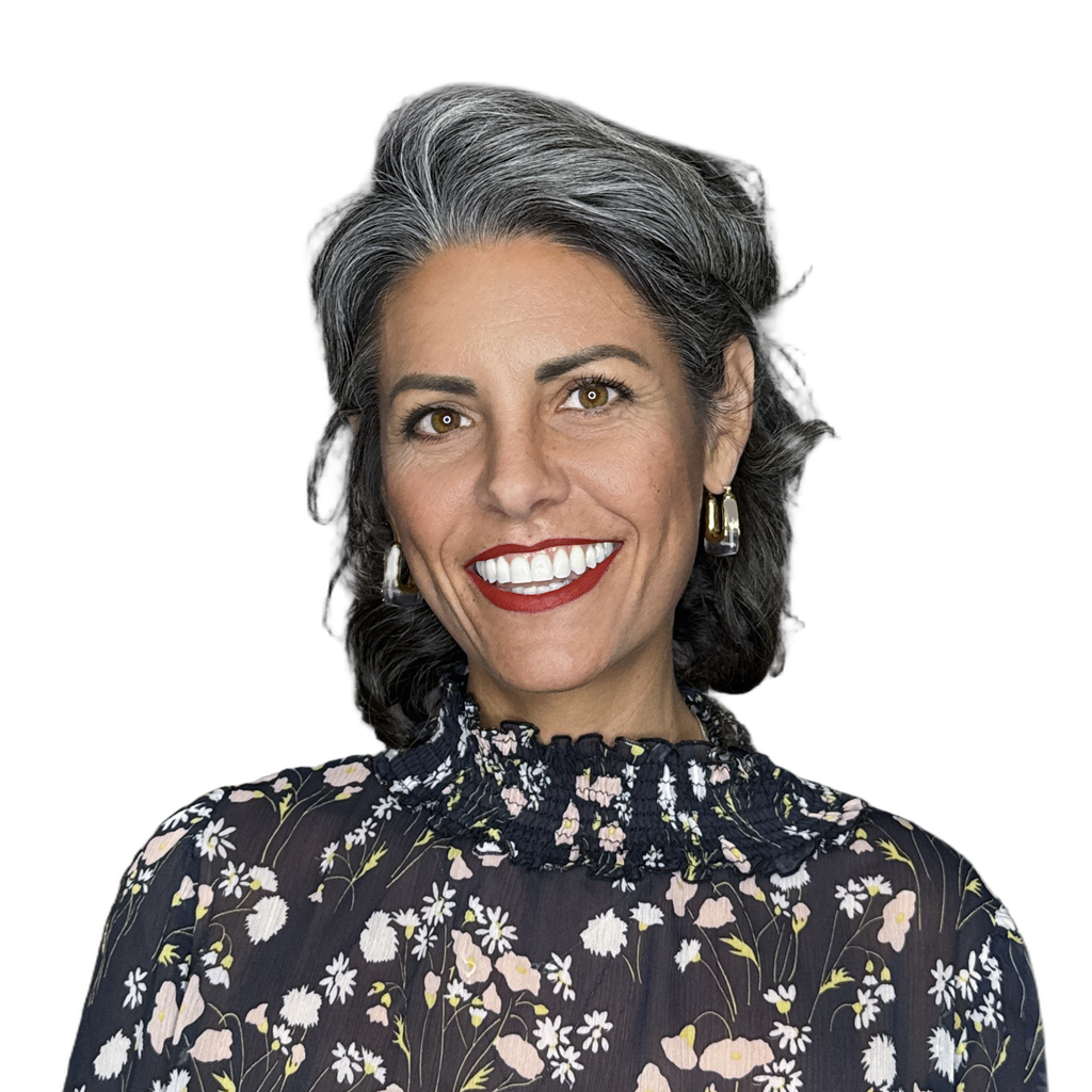 39. Executive director. Smiling middle-aged woman with gray hair and a floral blouse, set against a blurred office background