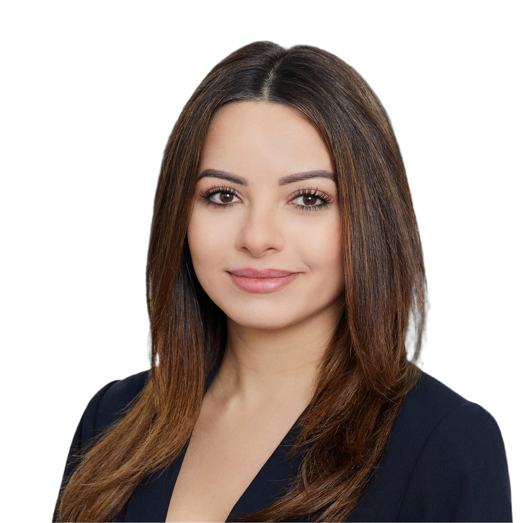 41. Development director. Woman with long brown hair, wearing a dark blazer, smiling against a blurred office building background