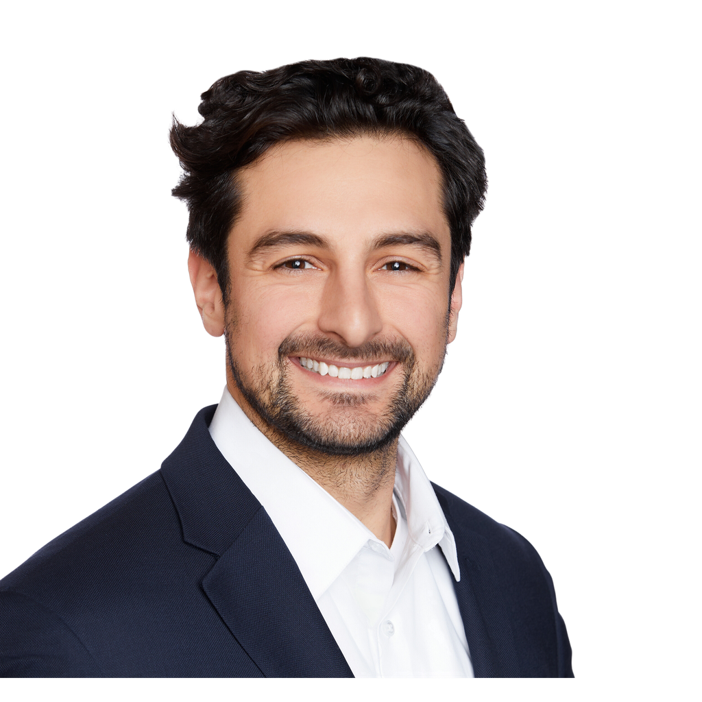 42. Board chair. Smiling man in a dark suit jacket and white shirt is featured in a professional headshot against a solid black background