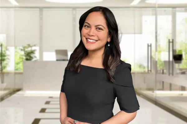 A woman in a black dress standing in an office.