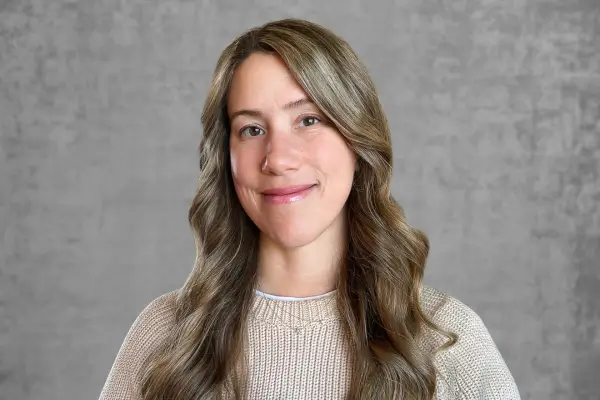 A smiling woman with long hair looking directly at the camera.