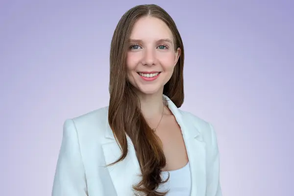 A woman wearing a white blazer and white shirt, exuding elegance and sophistication.